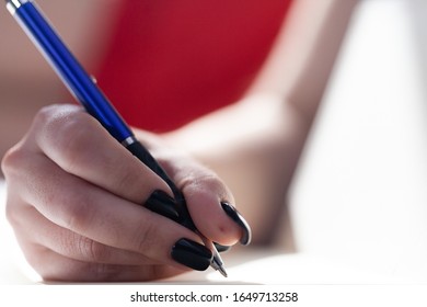 Female hands making notes in notebook
