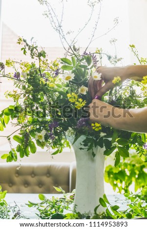 Hands make bouquet in vase