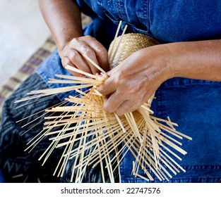 female hands manually weaving bamboo basket