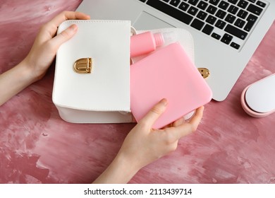 Female Hands With Medical Mask Case, Bag And Laptop On Color Background