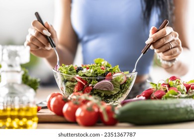 Female hands mixing a healthy spring salad made from various ingredients. Concept of healthy lifestyle. - Powered by Shutterstock