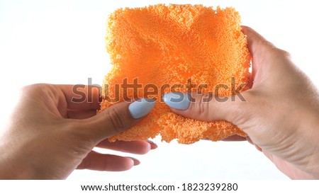 Female hands are molded from light airy multicolored orange plasticine, developing activities for children