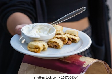 Female Hands Offering Greek Chicken Wrap To Taste On The Street, Outdoors.