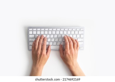 Female hands on the keyboard on a white background. Top view, flat lay.