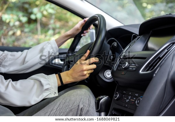 Female hands on steering wheel of a car. Woman
driver, car interior