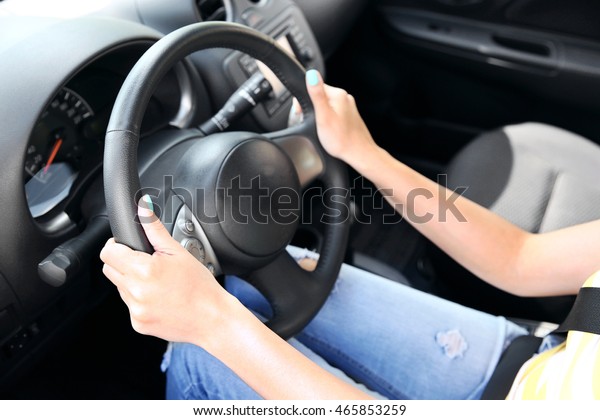 Female hands on steering\
wheel