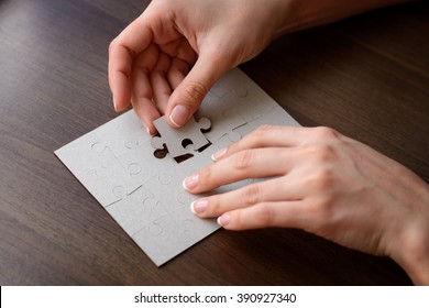 Female hands on a wooden office desk pick puzzle. Macro with blur, vignette  and soft focus. - Shutterstock ID 390927340
