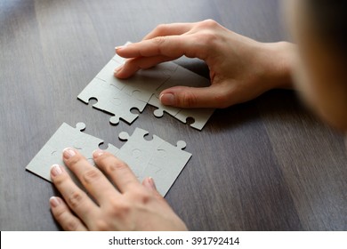 Female hands on a wooden office desk pick puzzle. Macro with blur, vignette  and soft focus. - Shutterstock ID 391792414