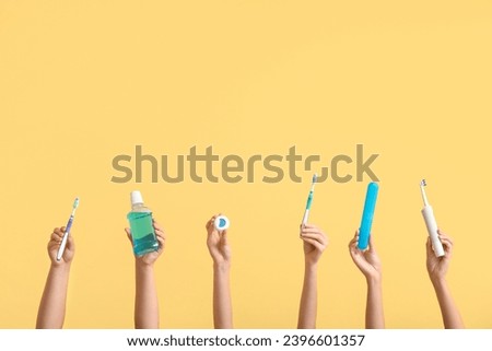 Female hands with oral hygiene supplies on color background