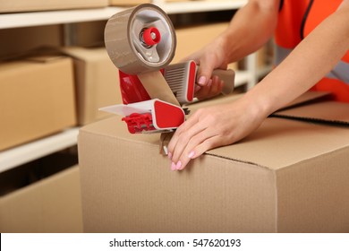 Female Hands Packing Box At Warehouse, Closeup