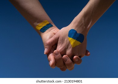 female hands painted in Ukraine flag colors yellow-blue holding. Stop the war and the power of Ukraine, patriotism and Kiev, strength and power