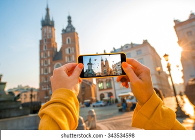 Female Hands Photographing St. Marys Basilica With Mobile Phone On The Sunrise In Krakow