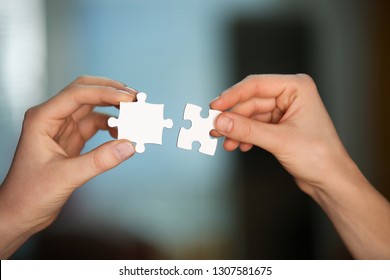 Female hands with pieces of puzzle on blurred background - Shutterstock ID 1307581675