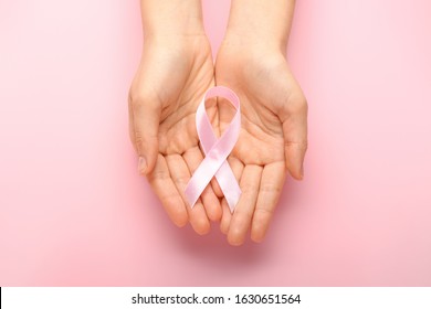 Female hands with pink ribbons on color background. Cancer awareness concept - Shutterstock ID 1630651564