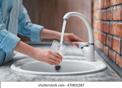 Female hands pouring water in glass cup
