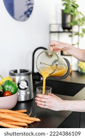 Female Hands Preparing Fruit Or Vegetable Smoothie In Electric Blender And Pouring Drink In Glass At Home Kitchen, Cropped Shot, Healthy Eating Concept