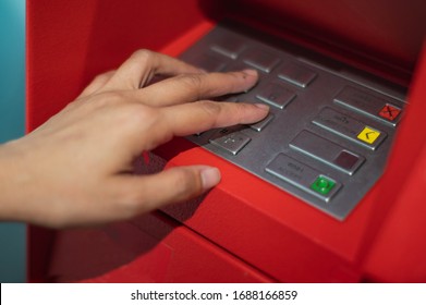 Female Hands To Press The ATM Key In The Red Cabinet.  Finger   Pressing A Pin Code On A Number Pad. Security Code On An Red Automated Teller Machine (ATM).