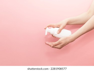 Female Hands Presses Dispenser OF Blank White Bottle, Plastic Tube On Pink Background. Hygiene, Cosmetic Beauty Product, Washing, Cleansing Intimate Gel, Foam. Daily Body Care. Horizontal, Copyspace.