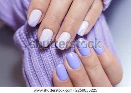 Female hands with a purple colour nails close-up. Nail design. Artistic manicure with a purple nail polish
