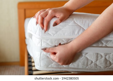 Female Hands Put New Mattress Pad On Orthopedic Mattress Corner. Bed Linen At Home. Sheet Is Worn On Soft Clean Mattress. Protection From Dirt Washed Linens Mattress Pad In Bedroom