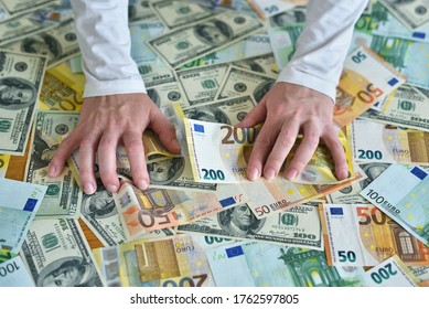 female hands reach for a heap of money. dollar and euro banknotes on the table. The concept of wealth, success, greed and corruption, lust for money