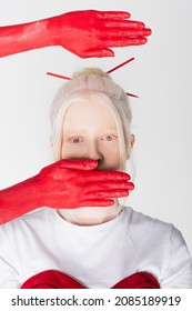 Female Hands In Red Paint Near Stylish Albino Model Isolated On White