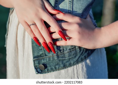 Female Hands With Red Stiletto Nail Design. Glitter Red Nail Polish Manicure. Young Female Model With Perfect Red Stiletto Nail Design.