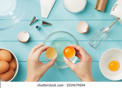 Female hands separate egg white from yolk for whipped cream. Step by step recipe of meringue with ingredients and utensils. Flat lay. - Powered by Shutterstock