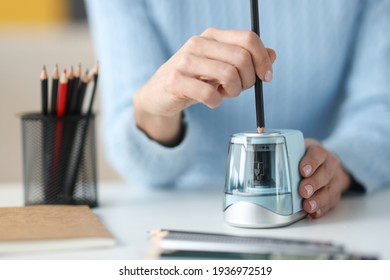 Female hands sharping pencil with electronic sharpener closeup - Powered by Shutterstock