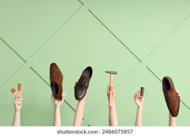 Female hands with shoes, brushes and craft tools on green wooden background. Shoe repair concept - Powered by Shutterstock