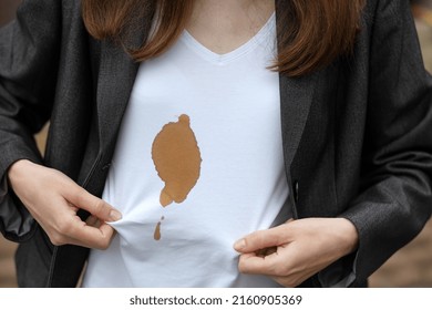Female hands showing dirty stain of coffee on white clothes. Outodoors. The concept of cleaning stains on clothes. High quality photo - Shutterstock ID 2160905369