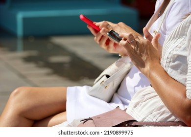 Female hands with smartphones close up. Two women using mobile phones while sitting on city street in summer - Shutterstock ID 2190899975