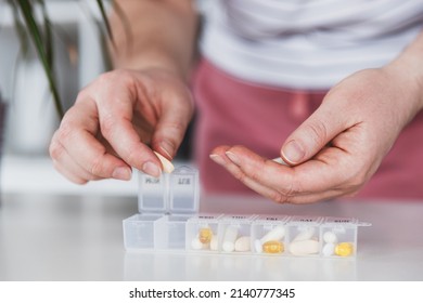 Female Hands Sorting Pills. Young Woman Getting Her Daily Vitamins At Home. Closeup Of Medical Pill Box With Doses Of Tablets For Daily Take A Medicine With Different White, Yellow Drugs And Capsules