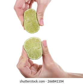 Female hands squeezing lime isolated on white