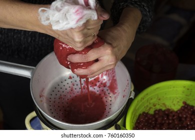 Female Hands Squeezing Red Berries Using Strainer And Cloth, Closeup Indoor Shot