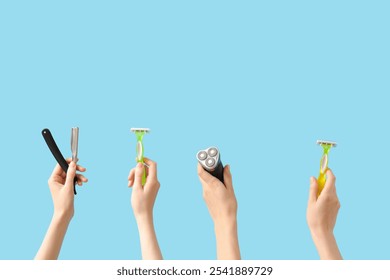 Female hands with straight razor, electric shaver and razors on blue background - Powered by Shutterstock