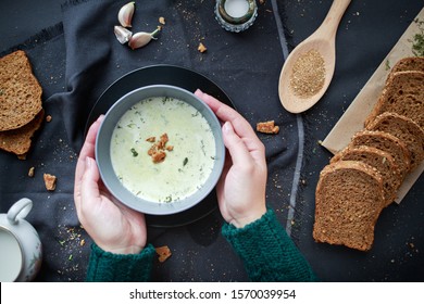 Female Hands In A Sweater Hold A Plate With Soup In Their Hands. Winter Food Concept. Home Comfort.