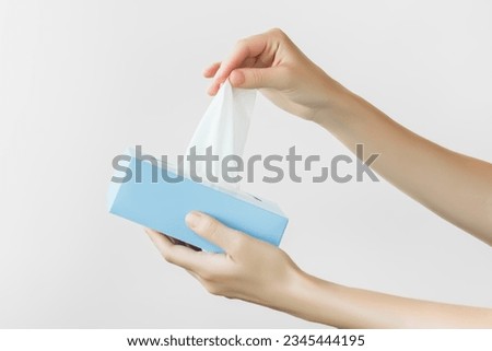 female hands take out a tissue from a cardboard box on a white background