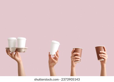 Female hands with takeaway paper cups and holder on purple background