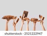 Female hands with tasty pastry and wooden baking utensils on grey background