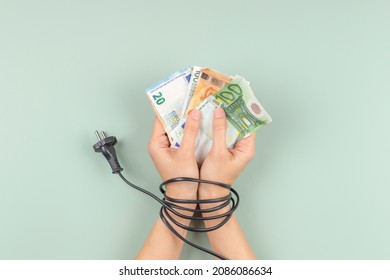 Female hands tied up with electric power cable cord. Energy efficiency, power consumption, rising electricity price and expensive energy concept