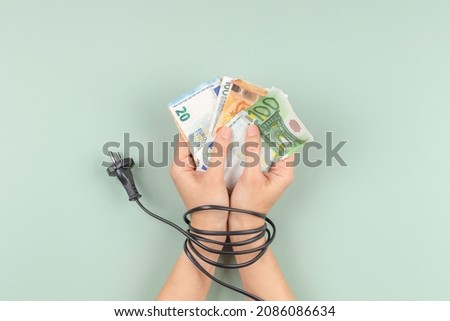 Female hands tied up with electric power cable cord. Energy efficiency, power consumption, rising electricity price and expensive energy concept