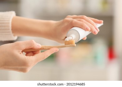 Female hands with tooth brush and paste on blurred background - Shutterstock ID 2012194685