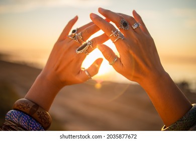 Female Hands Touch The Sun. Hippie Woman Hands With Silver Rings At Sunset. Indie Boho Vibes And Bohemian Style 