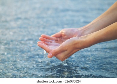 Female Hands Touching Sea Water