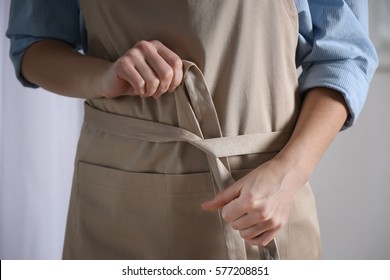 Female hands tying apron, closeup - Powered by Shutterstock