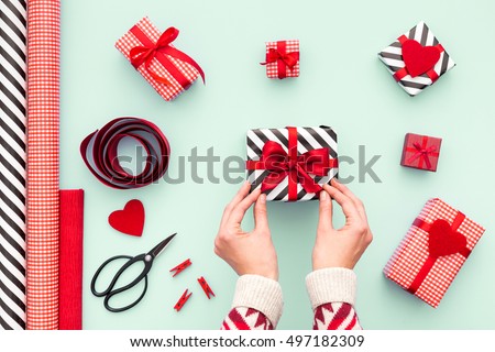 Female hands tying a red bow. Birthday, Valentines day, Christmas, New Year. Flat lay