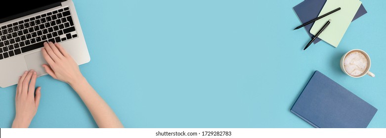 Female hands typing on laptop. Student supplies on a blue pastel background. Banner with copy space. - Shutterstock ID 1729282783