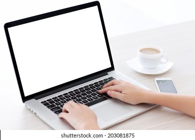 Female hands typing on a laptop keyboard with isolated screen in a white room on a desk with a phone and a cup of coffee
