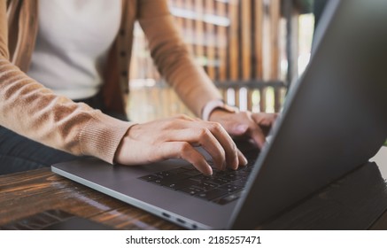 Female Hands Typing On Laptop While Sitting At Office Desk Indoors. Chatting In Facebook, Searching Information, Browsing. Technology Concept